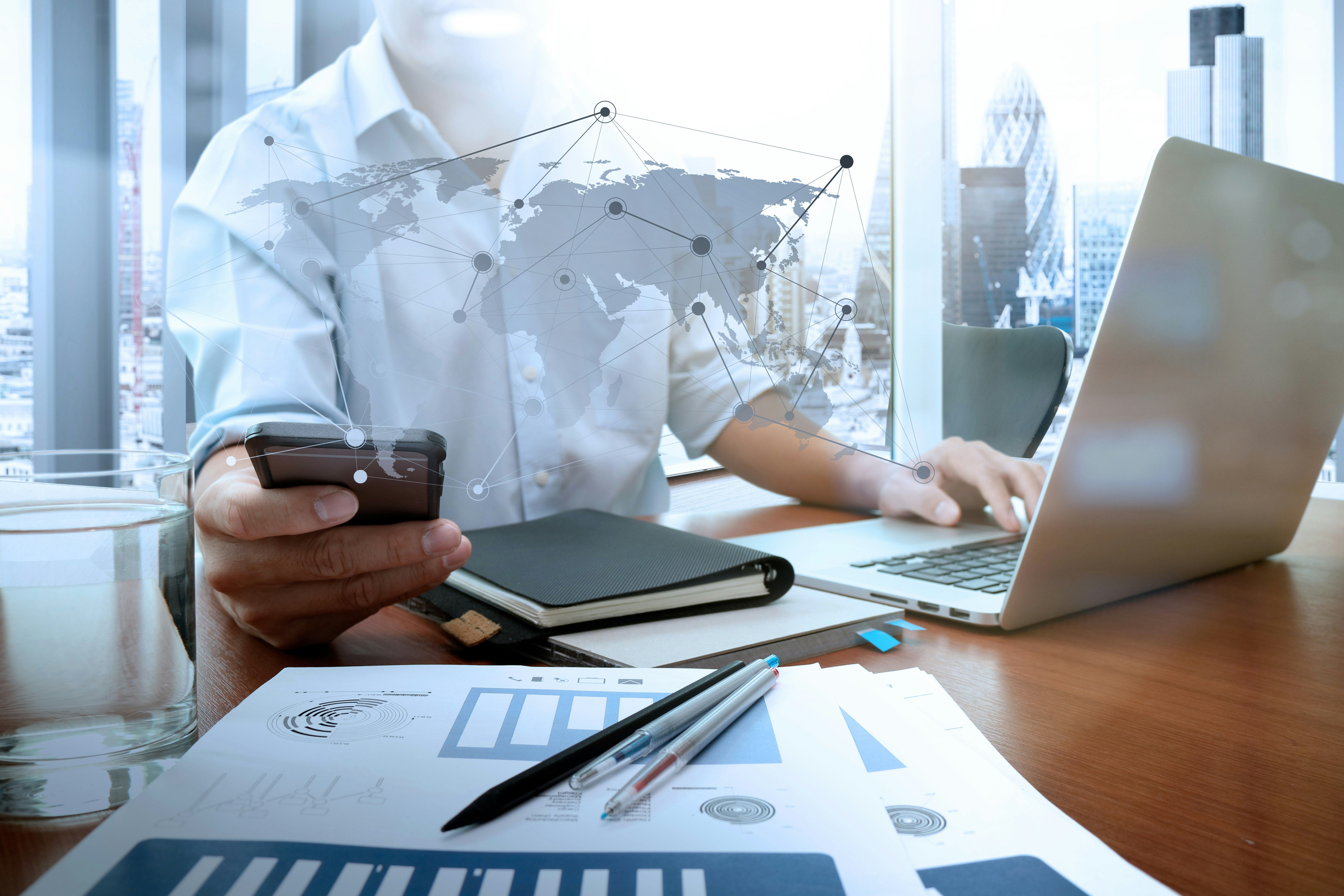 businessman hand working with new modern computer and smart phone and business strategy on wooden desk as concept