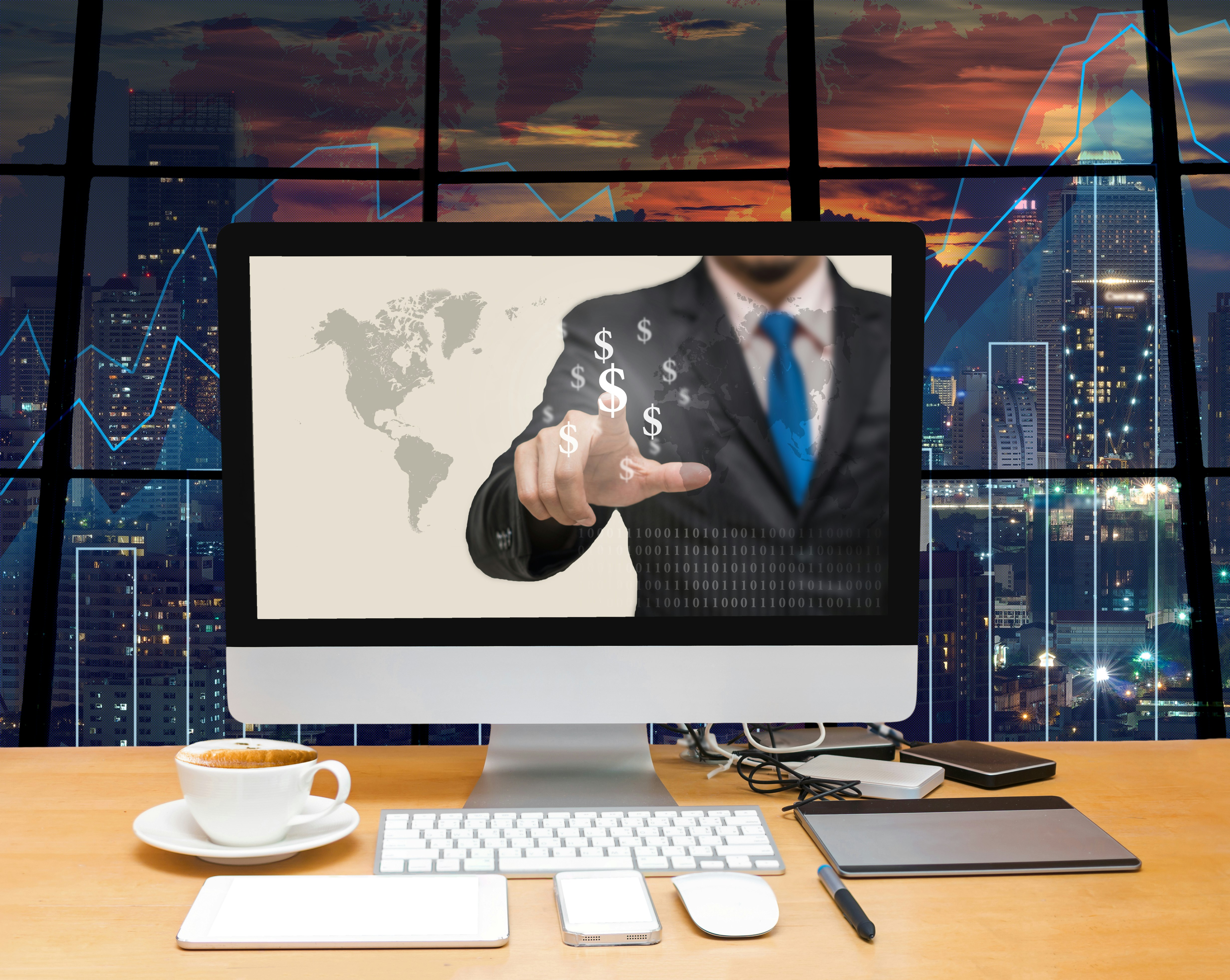 Workspace with computer desktop with Businessman point sign of money at the screen on the trading graph over the blurred photo of cityscape background,Elements of this image furnished by NASA