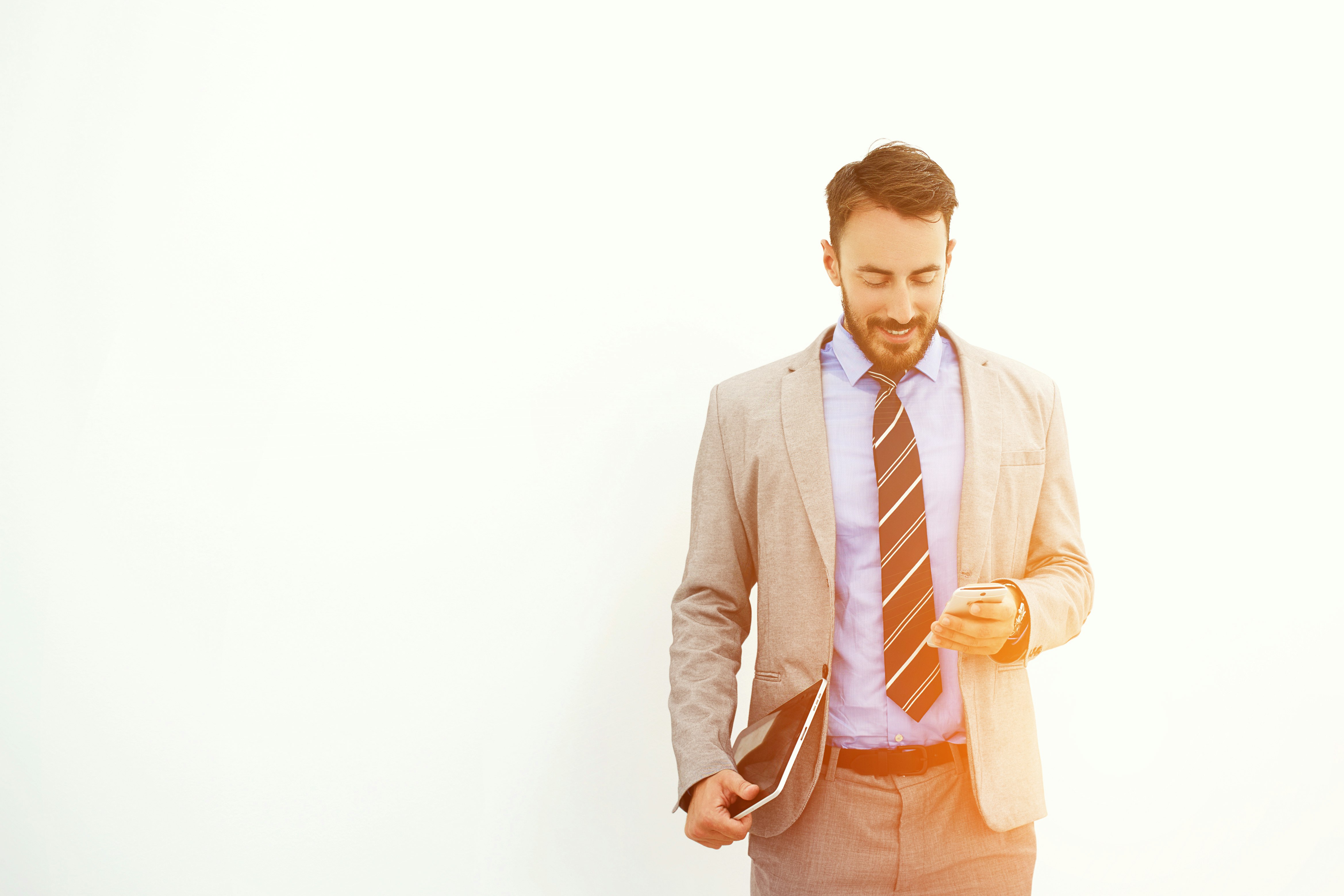 Man professional trader with digital tablet in hand is reading good news on mobile phone from his client about purchase of securities, while is standing near copy space for your advertising text